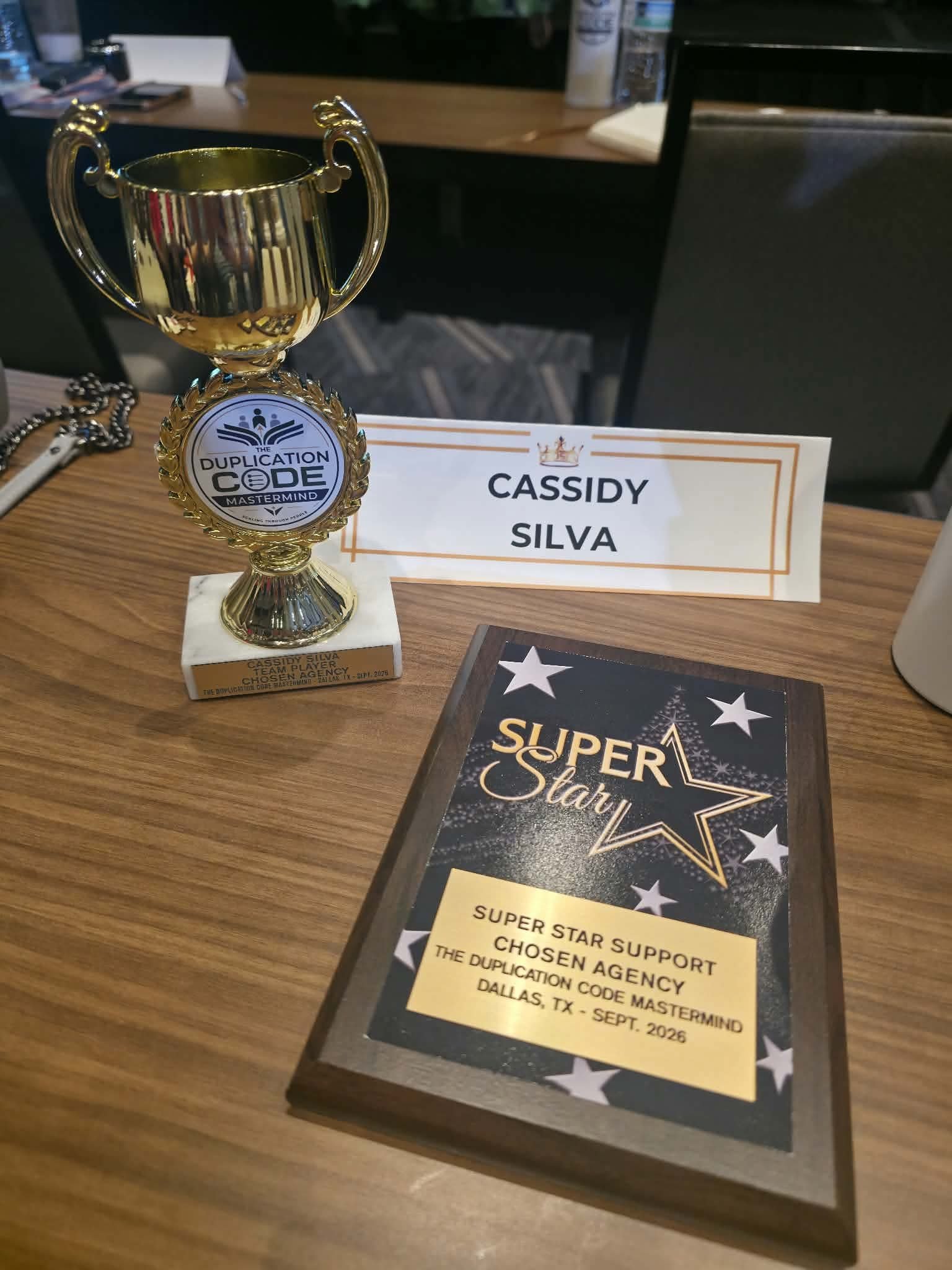 Cassidy Silva's Chosen Agency awards — Team Player trophy and Super Star Support plaque, Duplication Code Mastermind, Dallas 2026